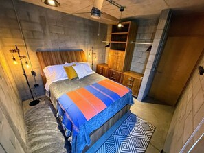 Ein Schlafzimmer mit einem Bett, Nachttischlampen, einem Kleiderschrank und einem Deckenventilator.