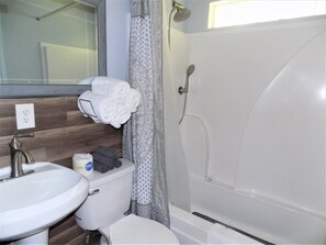 A bathroom with a white sink, toilet, and bathtub. - Winodee Cabin rustic relaxation close to town! (Pensacola)