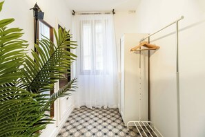 Een badkamer met een douche, een handdoekhouder en een potplant.
