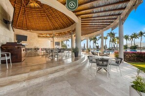 An outdoor lounge area with a thatched roof, seating arrangements, and a poolside view. - 4BR B-nayar Brisas 116 Mountain Views, Pool (Bucerías)