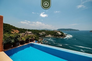 A pool overlooking a coastal area with buildings and greenery. - 4 BR Penthouse - Breathtaking Views - Private Pool (Ixtapa)