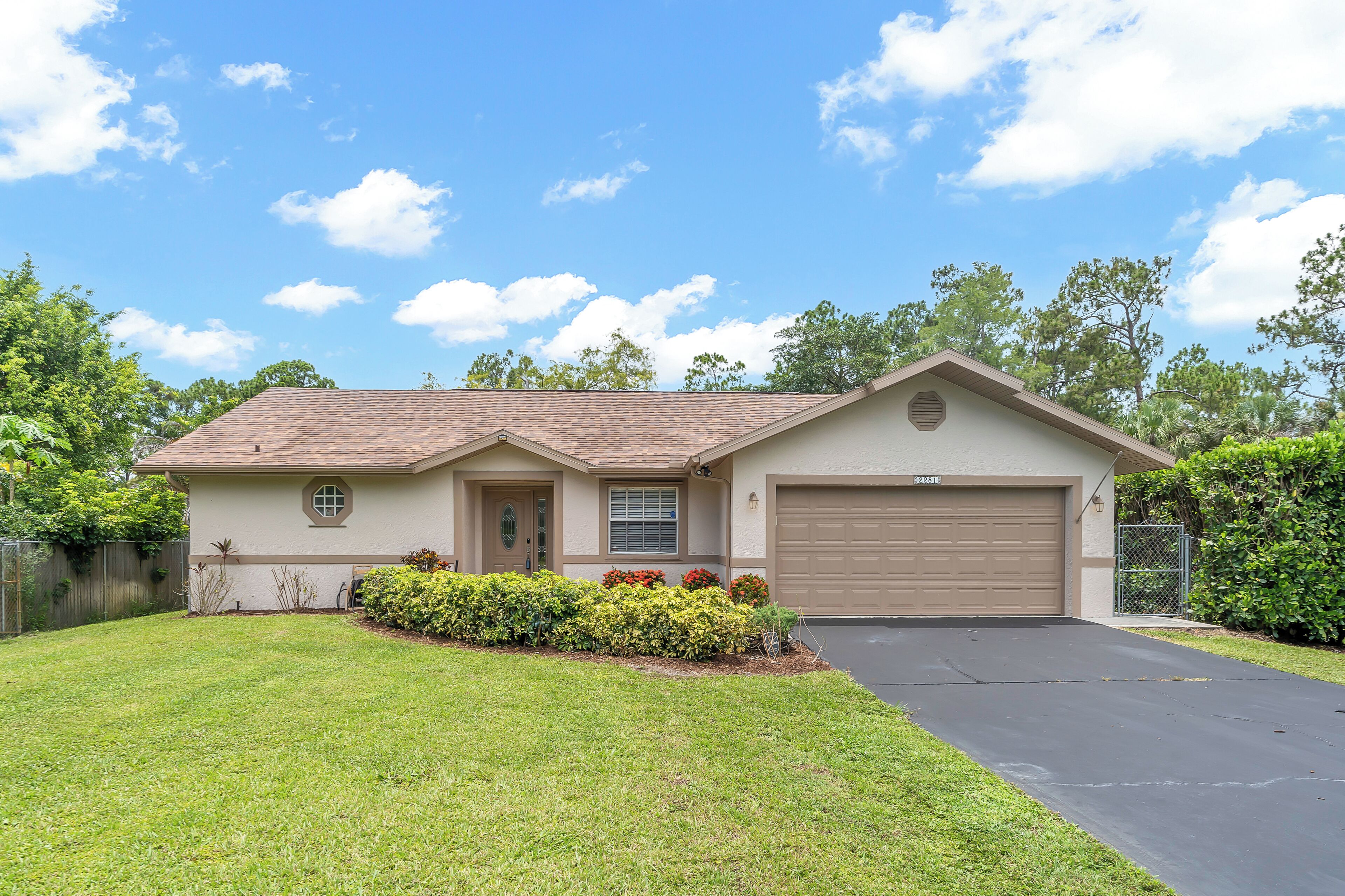 A single-story house with a front garage, a small porch, and a well-maintained lawn.