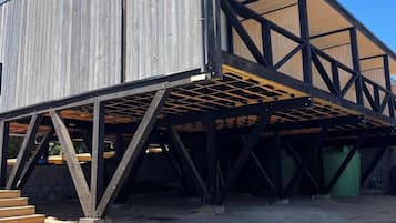 Eine Baustelle mit einem teilweise errichteten Gebäude, das eine Holzfassade und ein Metallgerüst aufweist.