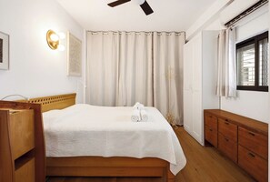 A neatly arranged bedroom with a bed, bedside table, and a wardrobe.