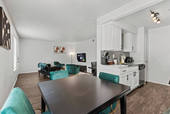 Um apartamento moderno com sala de jantar, cozinha e área de estar.