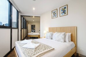 A hotel room with a large bed, a bedside table with a lamp, and a view through a glass door. - Banque Nook Cosy Southbank Stay near Crown and Yarra (Southbank)