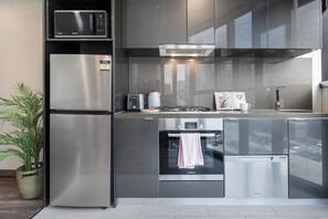 A modern kitchen with stainless steel appliances, including a microwave, refrigerator, oven, and dishwasher. - Banque Nook Cosy Southbank Stay near Crown and Yarra (Southbank)