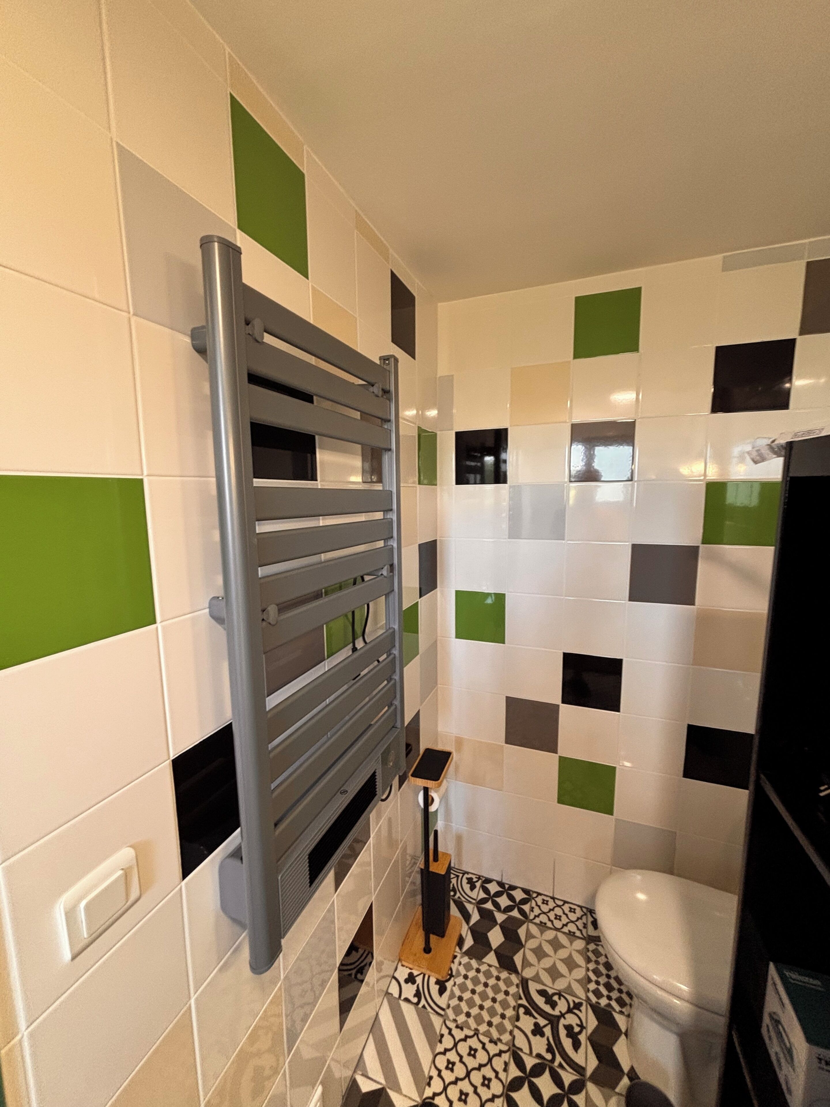 Een badkamer met toilet, wastafel en handdoekhouder.