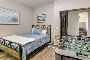 A bedroom with a bed, a foosball table, and a framed picture on the wall. - The Surprise Oasis, Heated Pool, Pet Friendly (Surprise)