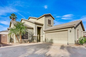 A single-story house with a garage, a covered patio, and a palm tree. - The Surprise Oasis, Heated Pool, Pet Friendly (Surprise)