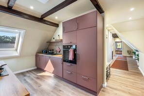 A modern kitchen with a built-in oven, a window, and a wooden countertop. - Heidschnucke Vacation Rental – 110 m² with a sauna for families and dogs in the Lüneburg Heath (Wriedel)