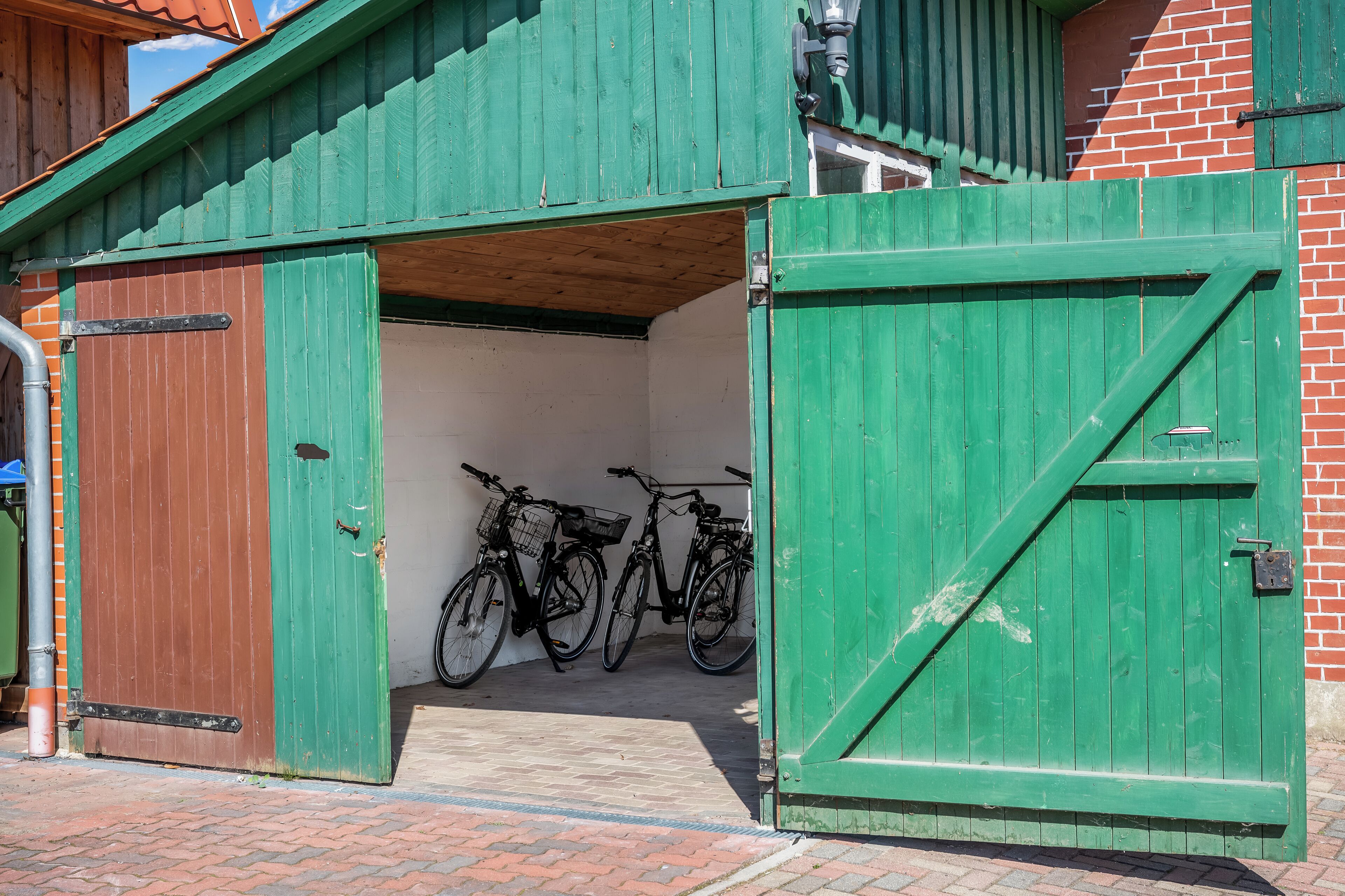 Una reja metálica verde con una bicicleta estacionada dentro de un edificio.
