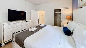 A hotel room with a bed, a television, a dresser, a closet, and a bedside lamp. - 7BR Solterra Resort Themed Home, Games, Fun,Disney (Davenport)