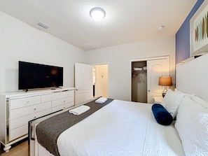 A hotel room with a bed, a television, a dresser, a closet, and a bedside lamp. - 7BR Solterra Resort Themed Home, Games, Fun,Disney (Davenport)