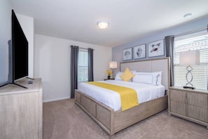 A hotel room with a bed, bedside tables, a television, and artwork on the wall. - 7BR Solterra Resort Themed Home, Games, Fun,Disney (Davenport)