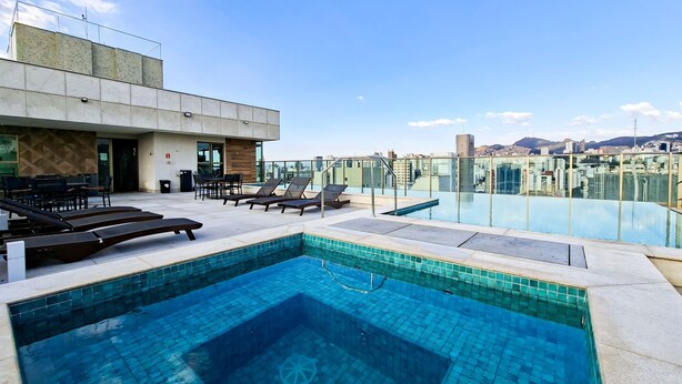 Un espace piscine aménagé sur le toit, avec des chaises longues et un coin repas.