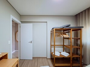 A room with a bunk bed, a wooden wardrobe, a desk, and a door. - Apto c Garagem Piscina e Sauna no Savassi (Belo Horizonte)