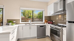 Una cocina moderna equipada con lavavajillas, estufa y refrigerador.