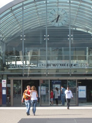 A modern building with a large glass facade and a clock on the upper level. - Brendy'Studio is located 7 minutes from Disneyland Paris (Magny-le-Hongre)