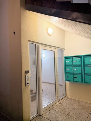 Eine Tür mit Zahlenschloss, ein Briefkasten und die Zahl 1 an der Wand.