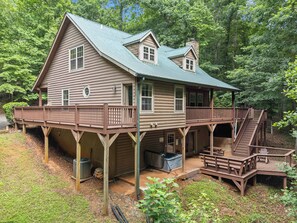 A two-story log cabin with a balcony and a covered porch area. - Inspiration by Blue Creek Cabins (Cleveland)