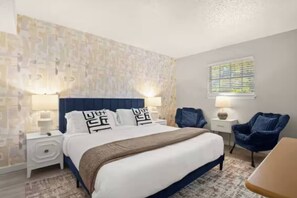 A hotel room with a bed, nightstands, a chair, and a window with blinds. - Central Austin • Parking • Sleeps 5 • Pet Friendly (Austin)