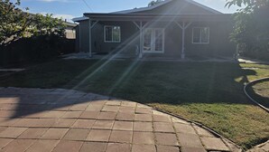 A residential house with a front lawn, a driveway, and a clear sky. - Lovely family-friendly 3-bedroom bungalow in peaceful Santa Paula (Santa Paula)