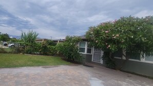 A residential area with a paved driveway, a lawn, and a house with a gated entrance. - Lovely family-friendly 3-bedroom bungalow in peaceful Santa Paula (Santa Paula)