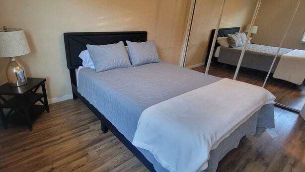 A bedroom with a bed, a nightstand, a lamp, and a hanging chair. - Lovely family-friendly 3-bedroom bungalow in peaceful Santa Paula (Santa Paula)