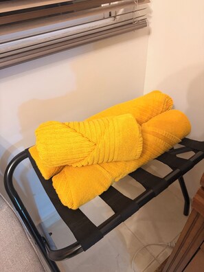 Un banc en métal sur lequel est posée une serviette jaune.