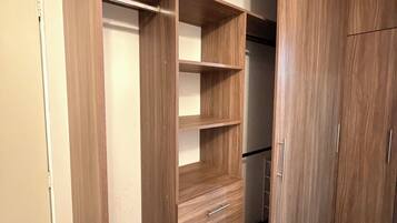 Un dressing avec des étagères en bois, des tiroirs et une tringle pour suspendre les vêtements.