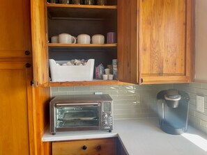 A kitchen with wooden cabinets, a toaster oven, and a Keurig coffee maker. - Vista Grande-2 Hot Tubs! 3 Large Decks! Arcade! (Ruidoso)