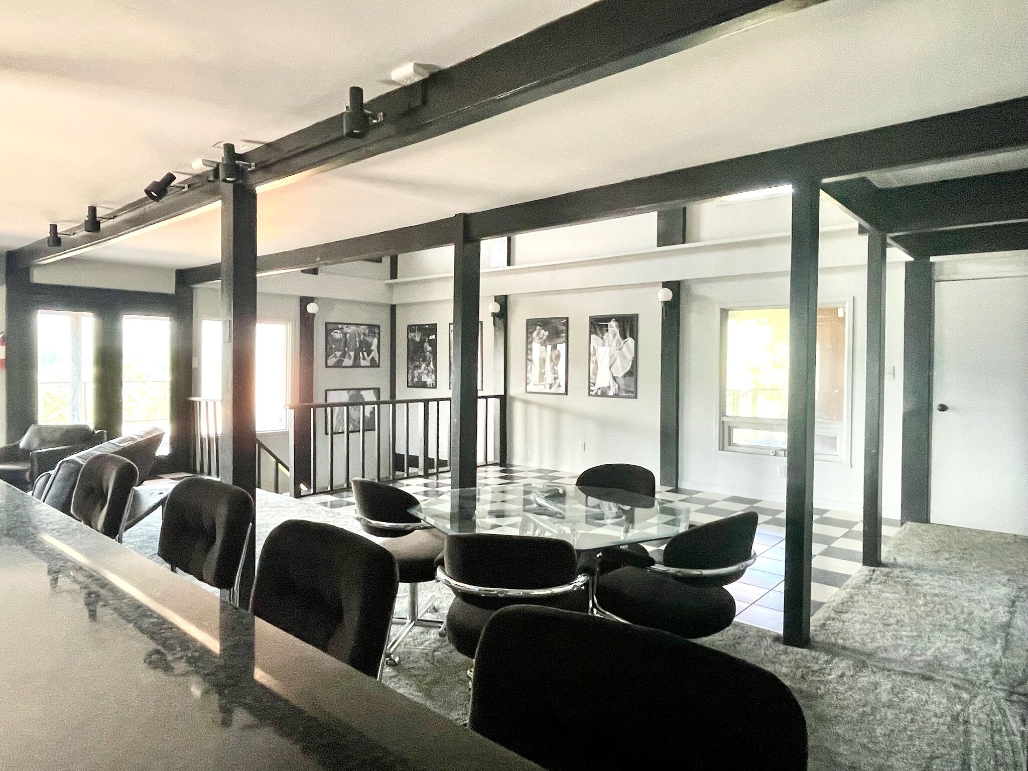 A conference room with a long table, chairs, and framed pictures on the walls.