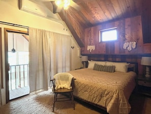 A bedroom with a bed, a chair, a window, and a door. - Vista Grande-2 Hot Tubs! 3 Large Decks! Arcade! (Ruidoso)