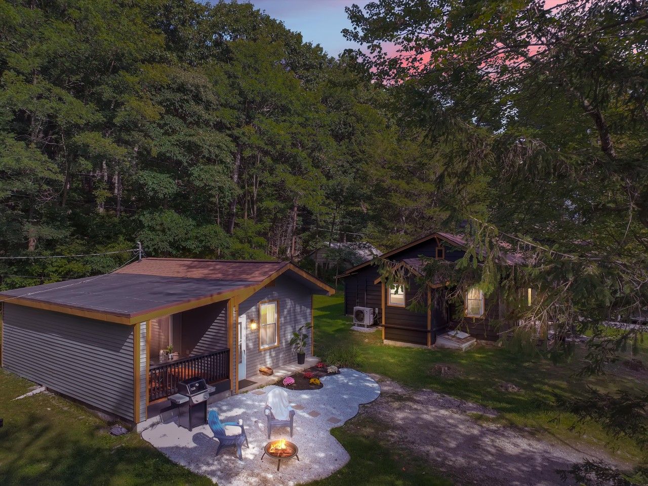Une cabane dotée d’un patio couvert, d’un foyer et d’une petite terrasse.
