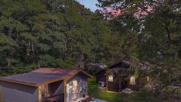 Une cabane dotée d’un patio couvert, d’un foyer et d’une petite terrasse.