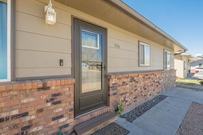 A residential building with a brick facade, a numbered address, and a door with a window above it. - Pedal Paradise II Cozy w/fenced yard (Fruita)