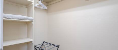 A closet with open shelves and a hanging rack.