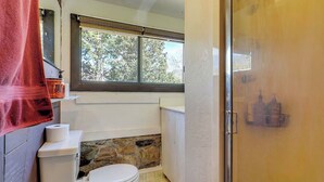 A bathroom with a toilet, a window, a shower, and a towel rack. - Charming 4-bed cottage with hot tub (Sandy)