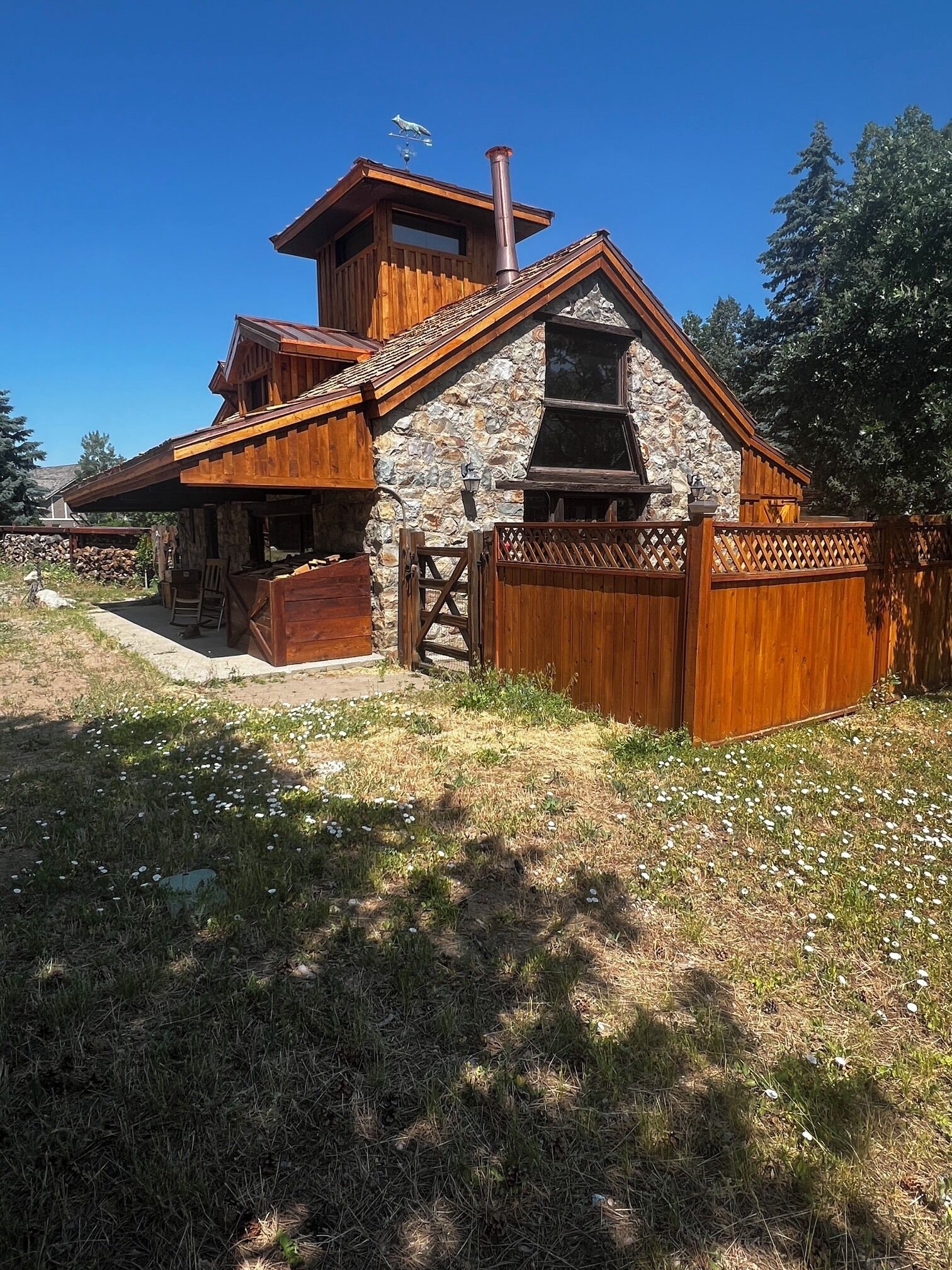 Una cabaña rústica con fachada de piedra, revestimiento de madera y una chimenea.