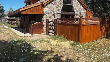 Una cabaña rústica con fachada de piedra, revestimiento de madera y una chimenea.