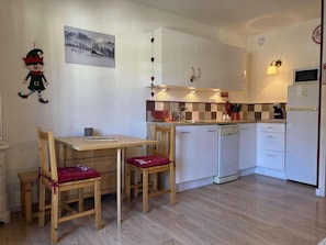 A compact kitchen with a dining table and chairs, a microwave, and a sink. - Ski-in/ski-out & foot of the slopes, 4th floor, balcony, tv, 30m², Les Orres (Les Orres)