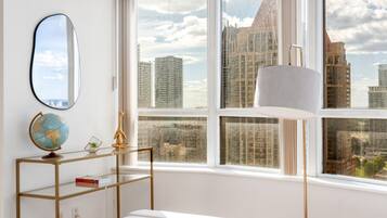 A room with a large window, a globe on a shelf, and a lamp.