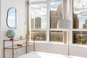 Ein Zimmer mit einem großen Fenster, einem Globus auf einem Regal und einer Lampe.