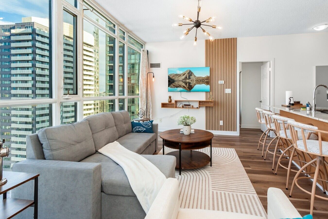 A modern living room with a sofa, a round coffee table, and a dining area with chairs.