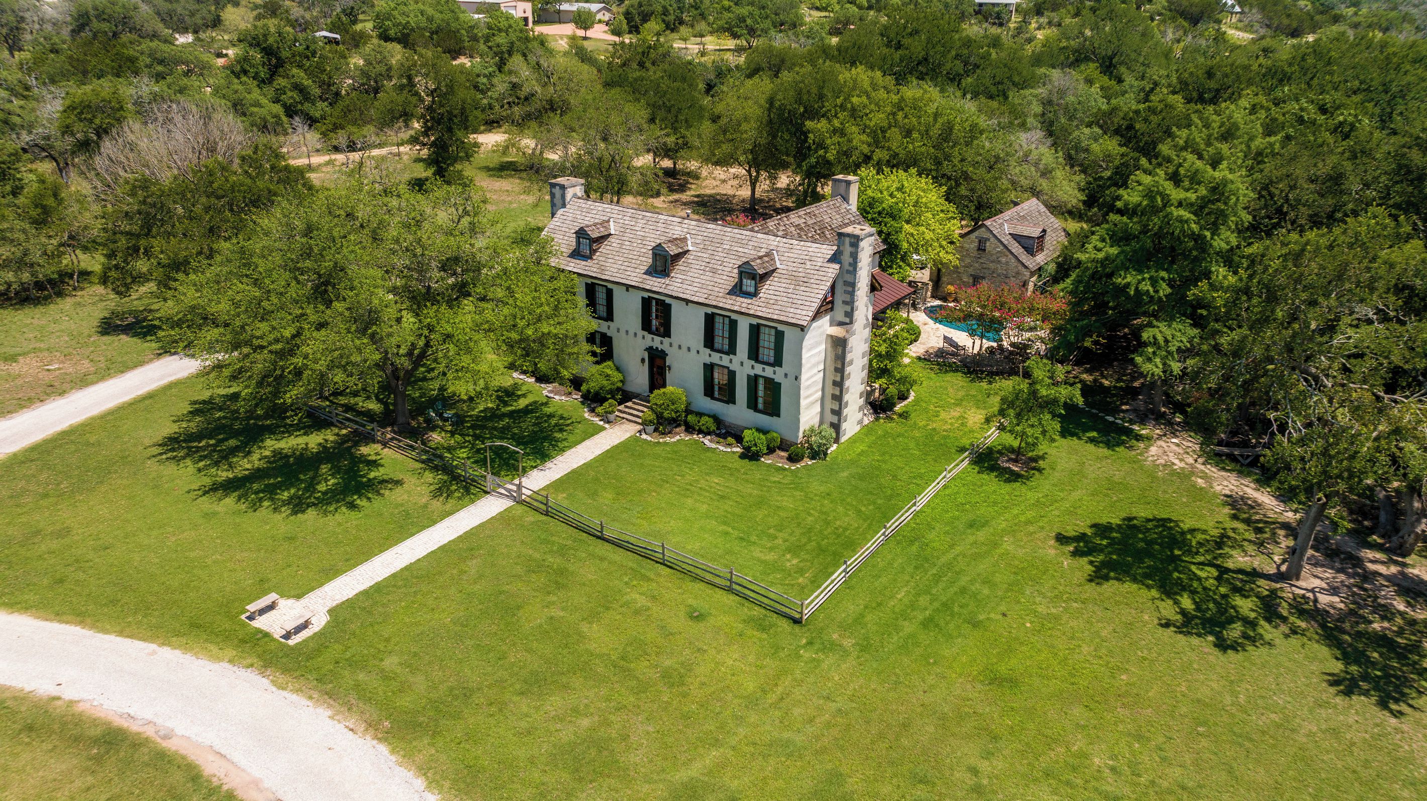Une grande maison à deux étages, dotée d’une pelouse bien entretenue et d’une piscine.