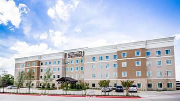 A Staybridge Suites hotel with a modern design, multiple floors, and a parking area.