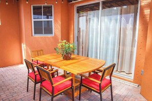 A wooden dining table with six chairs, a potted plant, and a window with a view. - Miami Lakes Retreat Heated Pool & Kids Play Area (Hialeah)