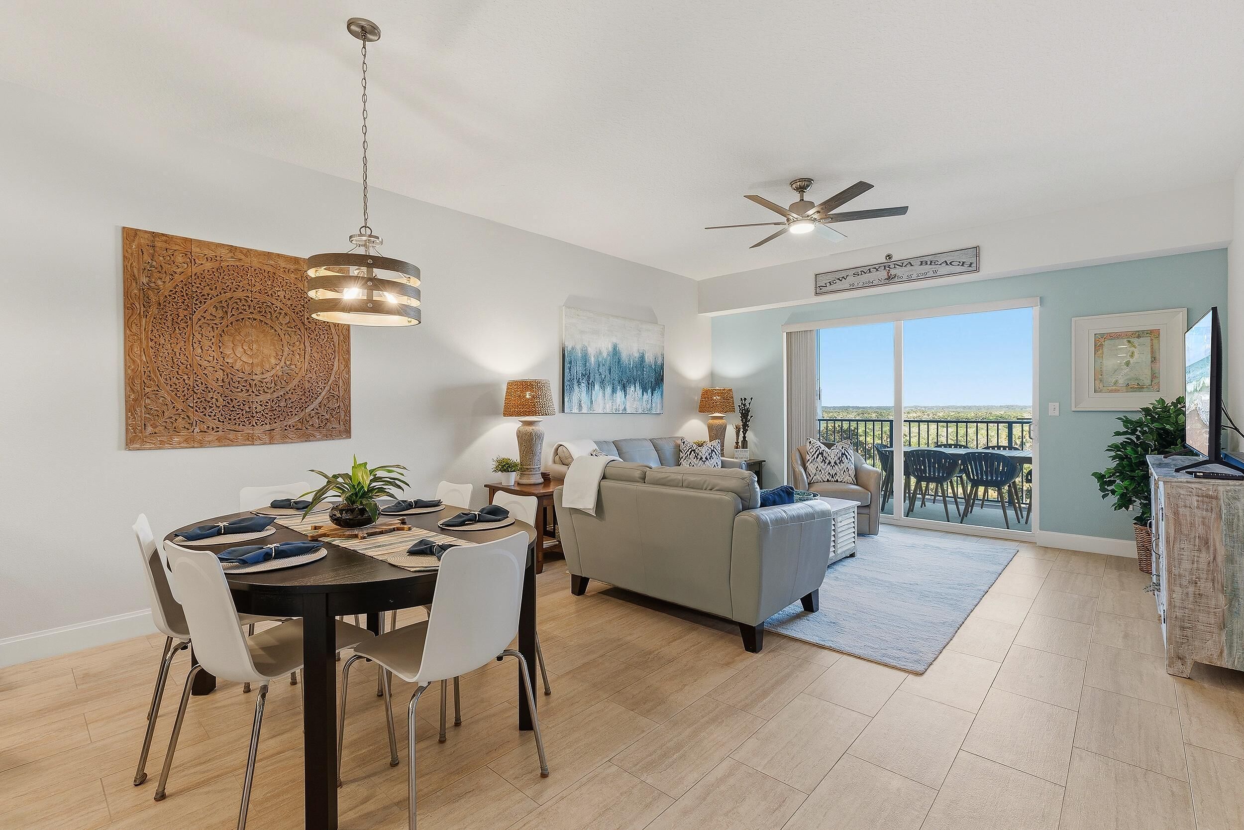 A spacious living area with a dining table, a sofa, and a ceiling fan.