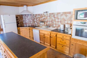 A kitchen with wooden cabinets, a sink, a dishwasher, a stove, and a microwave. - Ground floor, terrace, balcony, tv, ski locker, 135m², Valloire (Valloire)